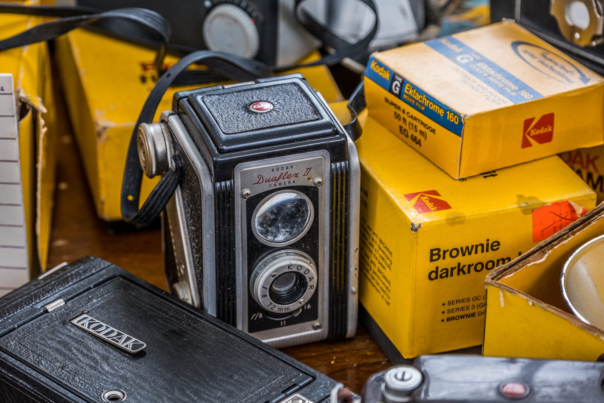 An old Kodak camera and a bunch of film rolls sitting on a table