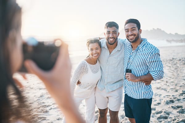 A professional photographer taking a picture of a group of people at the beach