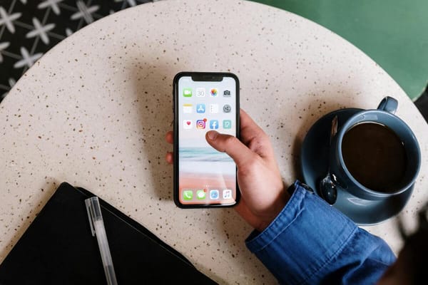 A person holding their phone with the screen showing instagram logo